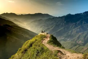 Hiker walking a mountain trail at sunrise