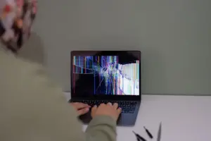 Person troubleshooting a laptop at a desk